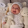 baby, basket, child, clock, cozy, cuddly_toy, cute, happy, headwear, indoors, infant, knitwear, newborn, portrait, sleeping_basket, smiling, soft_texture, teddy_bear, warm, white_clothing