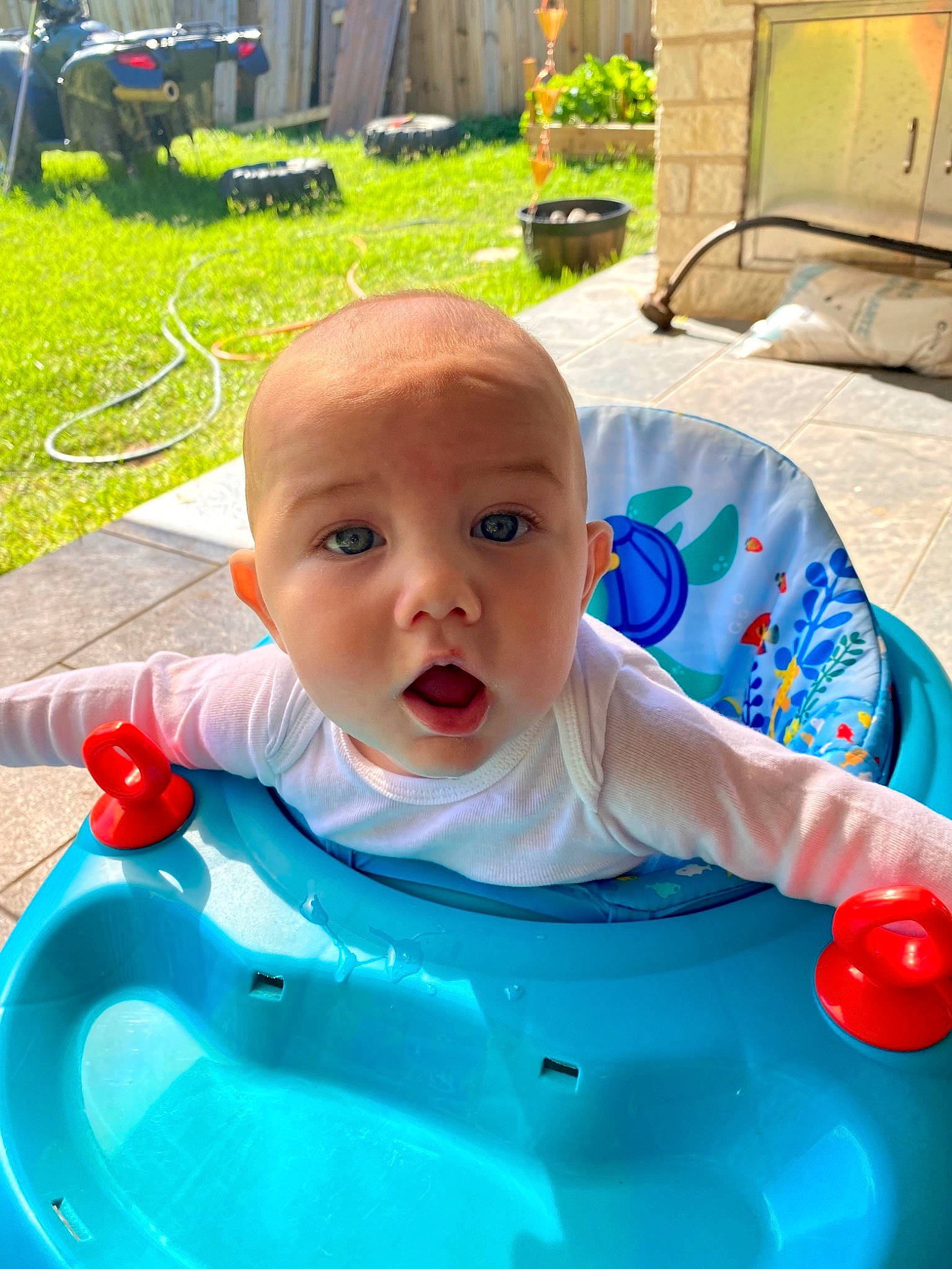 Corbin is registered to the contest to win money with this photo: baby, baby_products, baby_toddler_clothing, bib, blue, chair, cheek, child, event, fun, grass, green, happy, leisure, person, plant, recreation, sitting, surprise, toddler