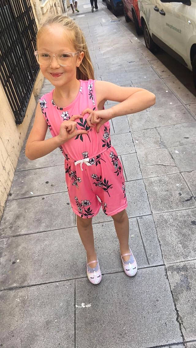 émilia participe au concours pour gagner de l'argent avec cette photo : car, child, city, clothing, dress, face, female, footwear, girl, head, path, person, photography, portrait, road, sandal, shorts, sidewalk, street, urban