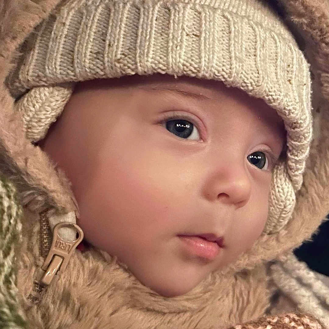 Leo is registered to the contest to win money with this photo: baby, beanie, bonnet, cap, clothing, face, happy, hat, head, hood, hoodie, knitwear, newborn, person, photography, portrait, smile, sweater, sweatshirt