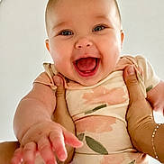 Baylee is registered to the contest to win money with this photo: baby, child, smiling, happy, hands, onesie, floral, person, portrait, infant, cute, reaching, skin, face, young, joy, closeup, expression, background, casual