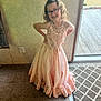 child, girl, glasses, dress, pink_dress, lace, sparkles, smile, pose, indoor, carpet, wall, door, glass_door, floor, young, happy, person, curly_hair, fashion