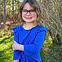 child, girl, glasses, blue_shirt, jeans, outdoor, forest, sunlight, smile, freckles, grass, trees, nature, casual, portrait, happy, young, wavy_hair, daisy_patch, bracelets
