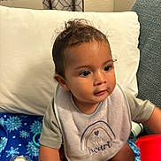Thomas joined the competition — help win amazing prizes! toddler, child, baby, bib, toy, indoor, blanket, curly_hair, pacifier, colorful, playtime, cute, sitting, clothing, face, expression, home, comfort, young_child, person