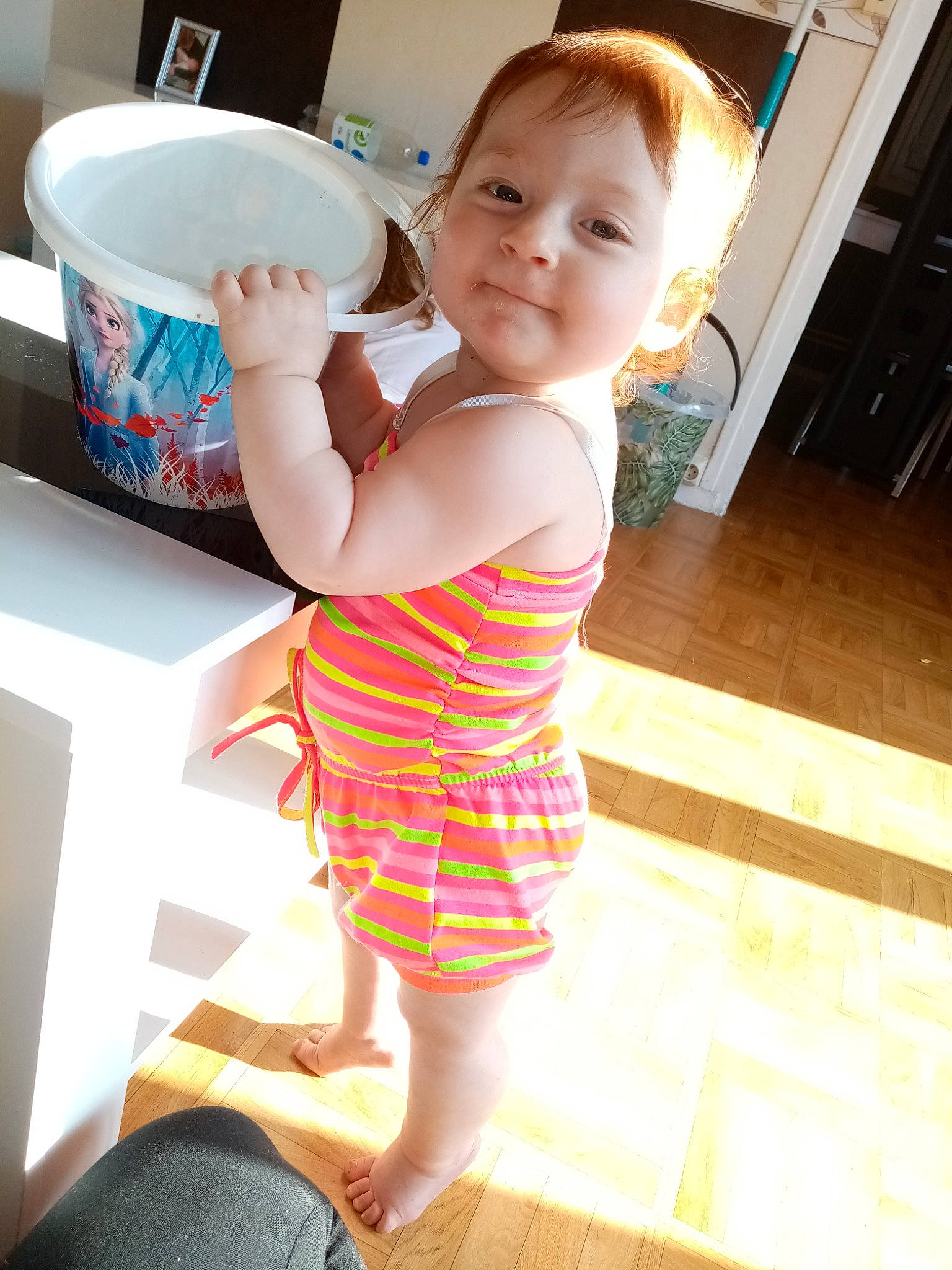 Lea participe au concours pour gagner de l'argent avec cette photo : baby, baby_toddler_clothing, child, cup, dishware, drinkware, finger, floor, flooring, hairstyle, joint, knee, person, serveware, shoulder, sleeve, standing, tableware, thigh, toddler