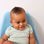 Evan participe au concours pour gagner de l'argent avec cette photo : baby, child, smiling, sitting, blue_chair, onesie, blanket, indoor, cute, young_child, happy, skin, face, hand, foot, furniture, portrait, casual, home, infant