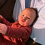 baby, child, pout, onesie, couch, pillow, indoor, infant, cute, face, hands, clothing, expression, reaching, sitting, cozy, soft_lighting, home, portrait, funny_face