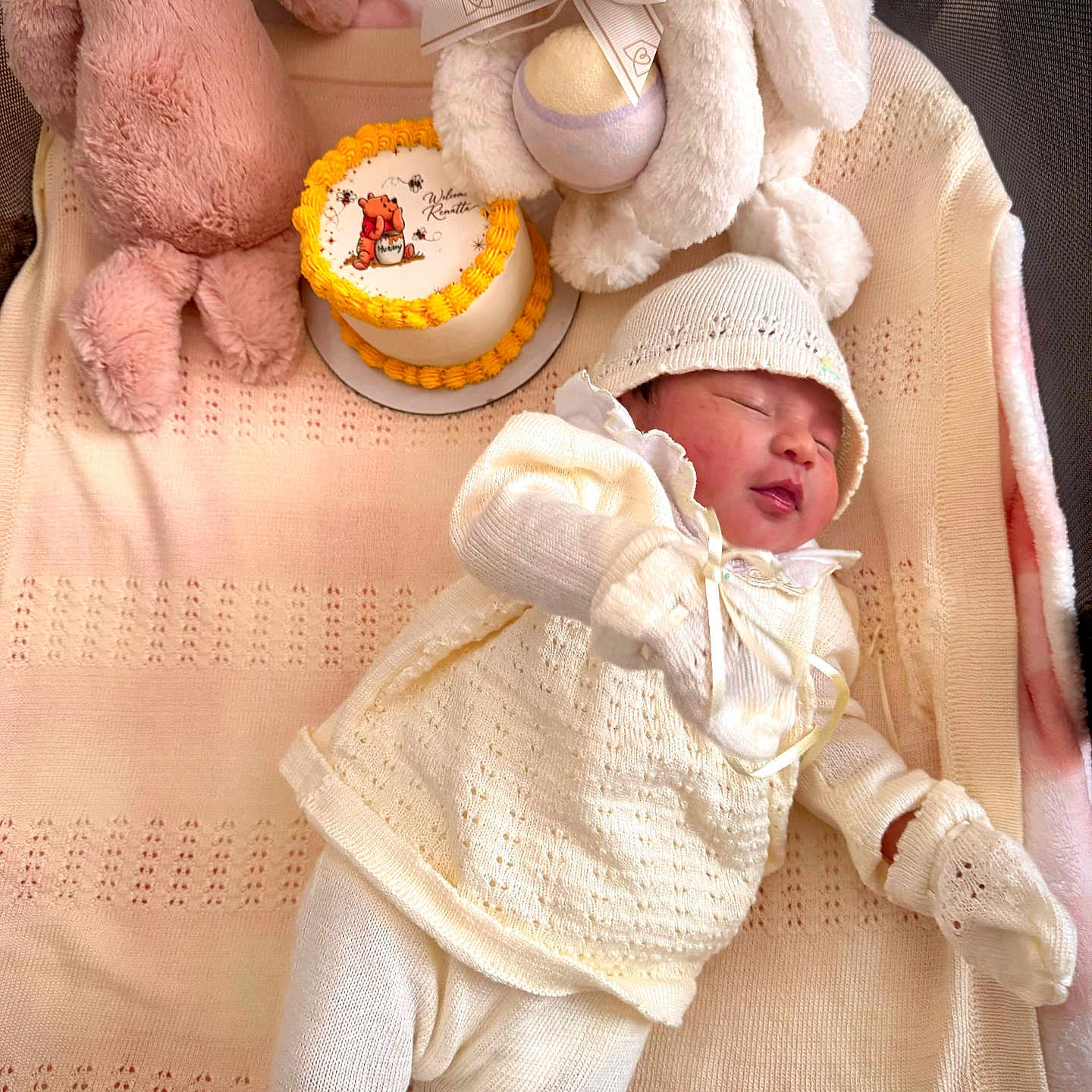 Renatta is registered to the contest to win money with this photo: baby, blanket, bunny, cake, cozy, cute, decorated_cake, hat, indoors, infant, knitwear, mittens, newborn, plush_toy, portrait, resting, sleeping, soft_texture, stuffed_animal, white_clothing