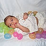 baby, infant, easter_eggs, colorful_eggs, blanket, cute, clothing, pattern, bunny, soft_texture, lying_down, hand, thumb_sucking, playful, pastel_colors, child, indoors, portrait, young_child, sleepy_eyes