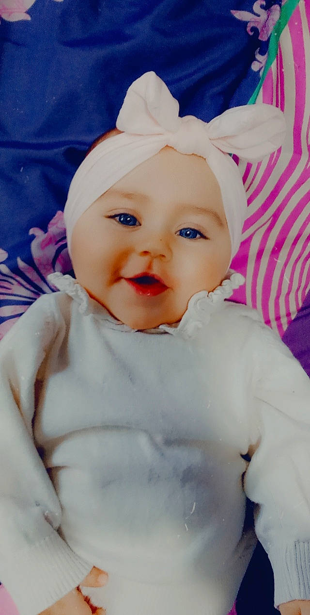 Mia participe au concours pour gagner de l'argent avec cette photo : baby, baby_toddler_clothing, cheek, child, eye, eyebrow, happy, hat, headband, headgear, headwear, iris, lip, magenta, person, pink, skin, sleeve, smile, textile