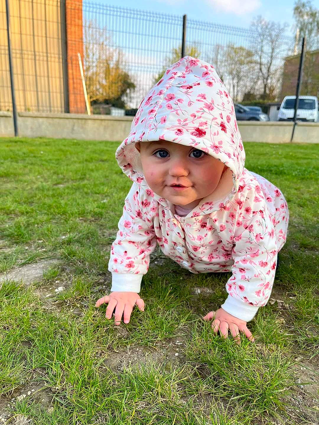 Mia participe au concours pour gagner de l'argent avec cette photo : baby, baby_toddler_clothing, cap, crawling, dress, facial_expression, flooring, fun, grass, happy, headwear, outerwear, pattern, people_in_nature, person, pink, plant, recreation, sky, sleeve