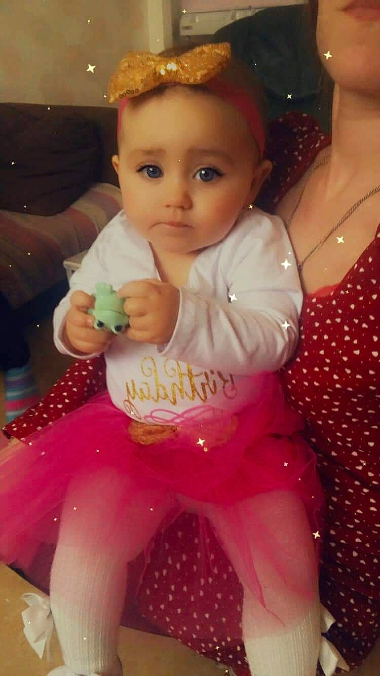 Mia a rejoint le concours — aidez-le/la à gagner de superbes lots ! arm, baby, baby_products, baby_toddler_clothing, cheek, child, event, facial_expression, fashion_accessory, fun, happy, jewellery, lap, magenta, pattern, person, pink, sitting, skin, thumb