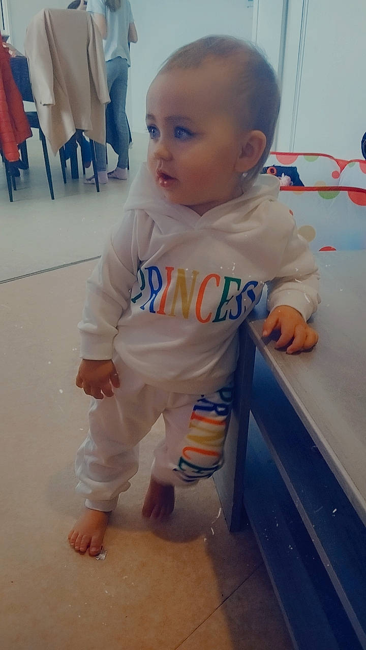 Mia participe au concours pour gagner de l'argent avec cette photo : baby, baby_toddler_clothing, cheek, child, cleanliness, electric_blue, floor, flooring, foot, fun, happy, human_leg, joint, person, sitting, skin, sleeve, t_shirt, thumb, toddler