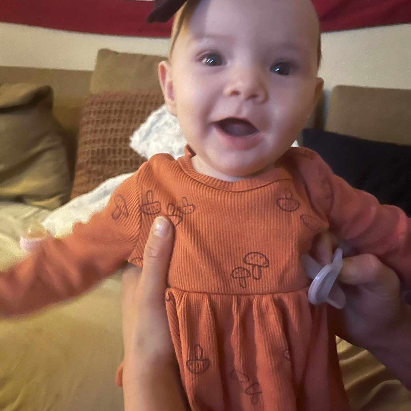 Ila is registered to the contest to win money with this photo: accessories, baby, bodypart, clothing, couch, cushion, dress, face, finger, flag, furniture, hand, happy, head, homedecor, indoors, person, photography, portrait, smile