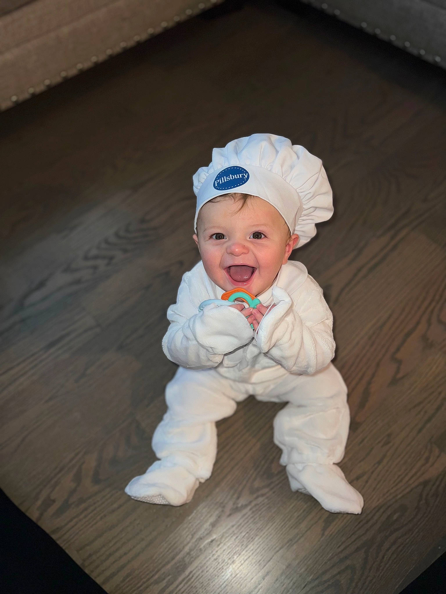 Gianni is registered to the contest to win money with this photo: baby, baby_toddler_clothing, cap, child, flash_photography, floor, flooring, fun, fur, happy, hardwood, hat, headgear, person, personal_protective_equipment, sitting, sleeve, smile, toddler, wood