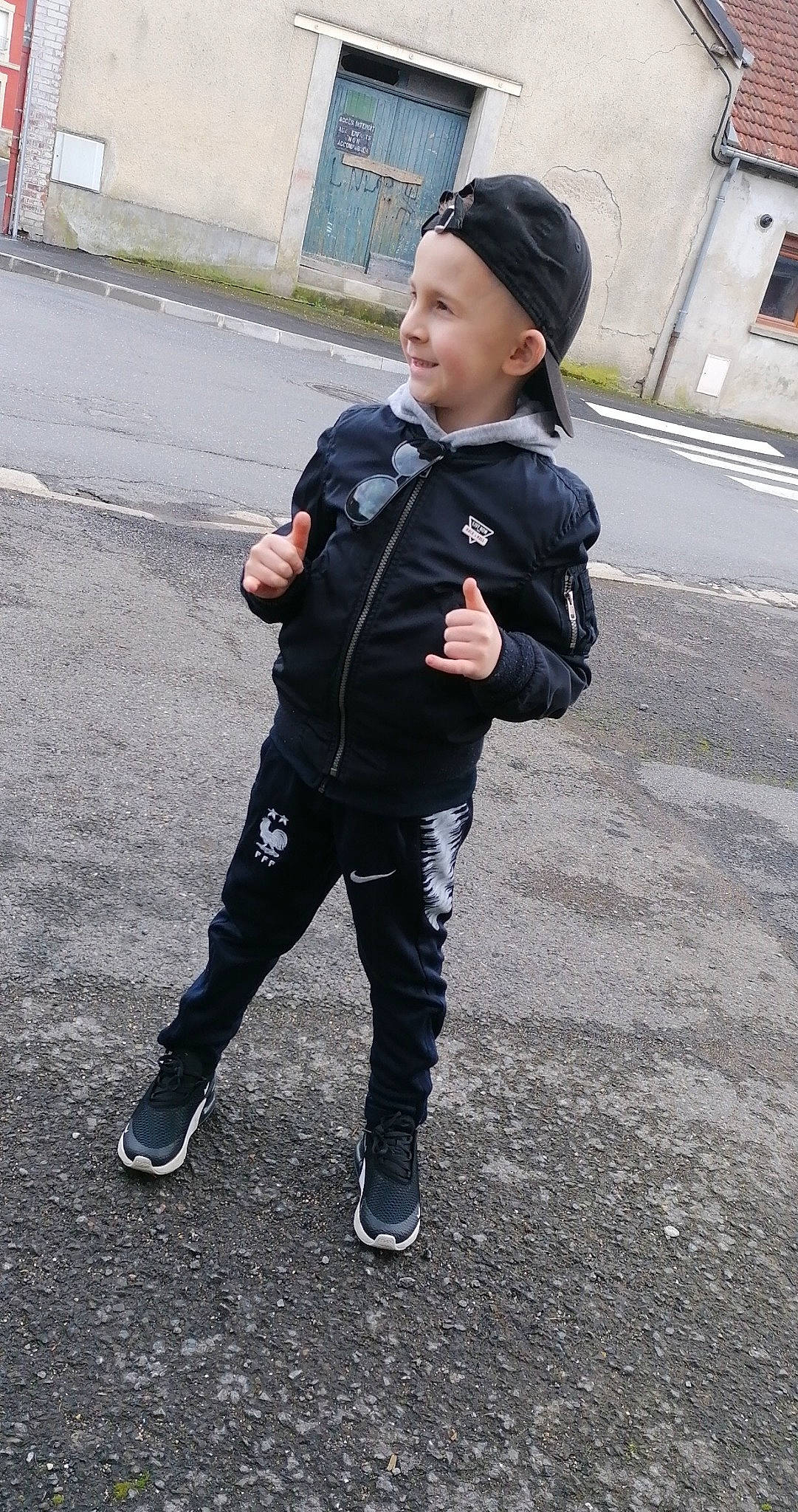 Ethann participe au concours pour gagner de l'argent avec cette photo : asphalt, cap, denim, face, footwear, gesture, glove, hat, head, headwear, jacket, joy, pattern, pedestrian, person, personal_protective_equipment, recreation, road_surface, shoe, sleeve