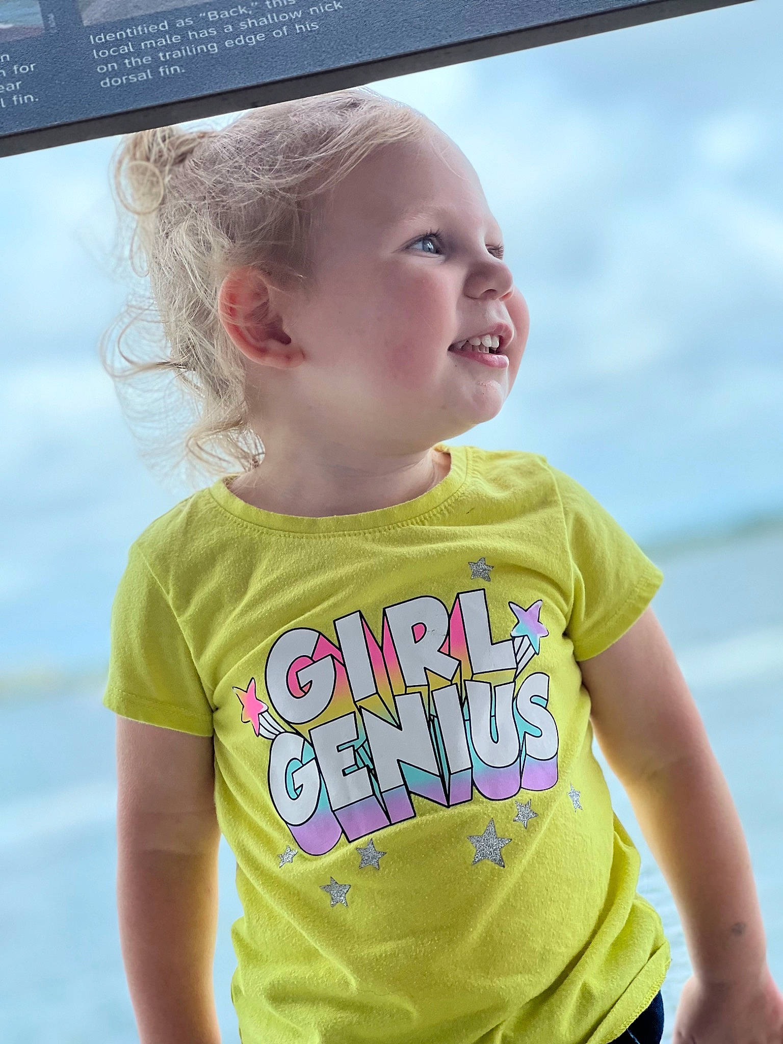 Harper is registered to the contest to win money with this photo: azure, baby, baby_toddler_clothing, cheek, cool, face, fun, grass, happy, head, iris, leisure, neck, person, skin, sleeve, smile, standing, summer, t_shirt