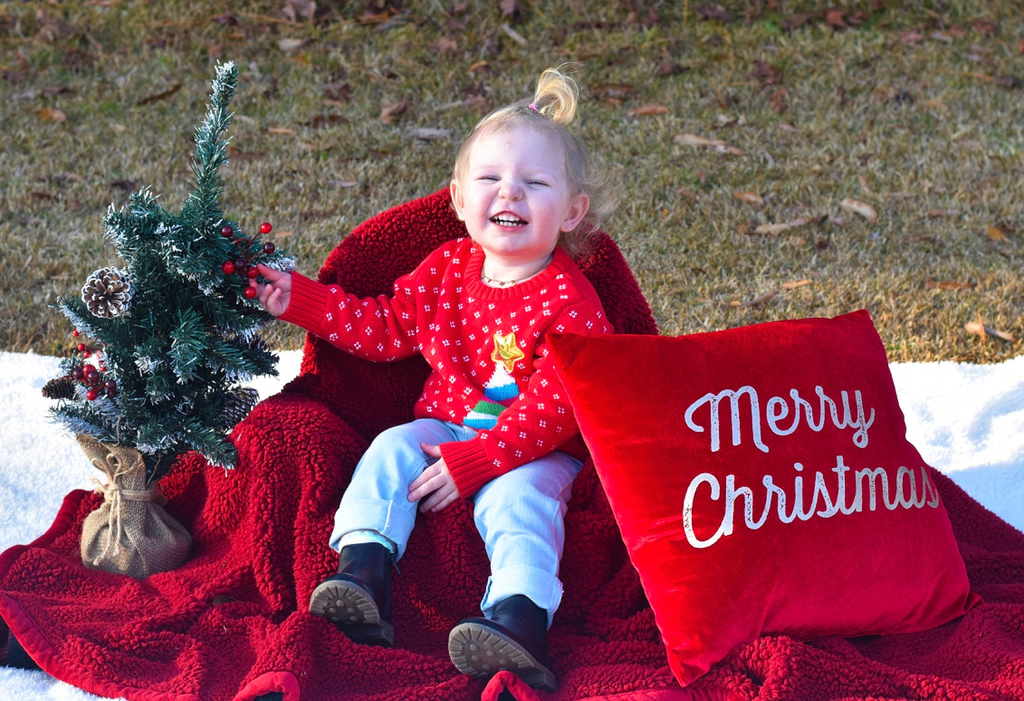 Harper joined the competition — help win amazing prizes! child, christmas_eve, event, facial_expression, fun, grass, happy, holiday, interaction, joy, lap, leisure, people_in_nature, person, play, recreation, red, sitting, smile, toddler