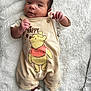 baby, infant, blanket, winnie_the_pooh, clothing, cute, face, expression, socks, sleepwear, person, newborn, soft_texture, lying_down, smile, indoors, child, young, comfortable, adorable