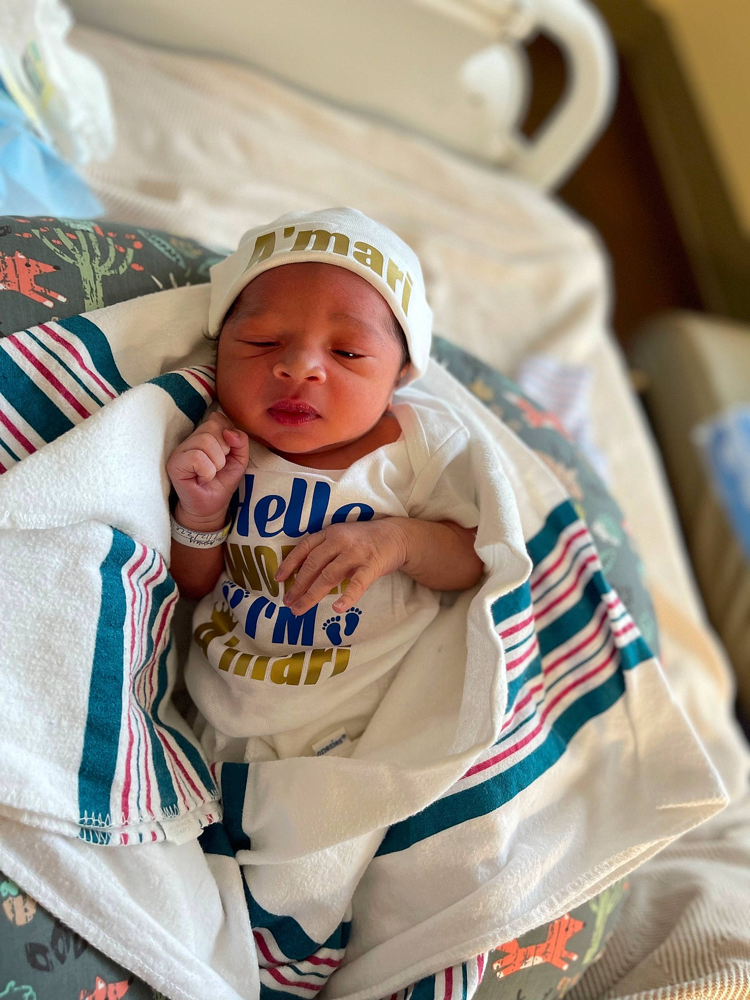 Amari joined the competition — help win amazing prizes! baby, baby_products, baby_safety, baby_sleeping, baby_toddler_clothing, bedding, cap, child, comfort, couch, happy, hat, headwear, linens, pattern, person, room, sitting, sleeve, t_shirt