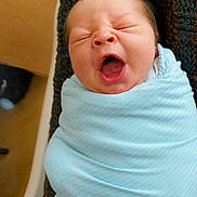 Stetson is registered to the contest to win money with this photo: newborn, baby, swaddled, blanket, blue, yawning, infant, sleepy, cute, face, head, portrait, closeup, person, cozy, texture, soft, wrapped, indoor, child
