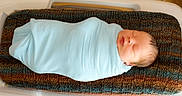 Stetson is registered to the contest to win money with this photo: newborn, baby, swaddled, sleeping, blanket, knitted_cushion, hospital_bassinet, infant, peaceful, face, head, person, cute, resting, indoors, soft_texture, light_blue, cozy, wrapped, tiny