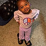 Nyomi is registered to the contest to win money with this photo: blanket, carpet, child, cute, earrings, fashion, floor, girl, happy, home, indoors, peace_symbol, portrait, pose, purple_clothing, sandals, smile, standing, star_pattern, young