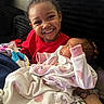 Nyomi is registered to the contest to win money with this photo: baby, blanket, child, clothing, couch, cozy, cute, family, happy, holding, indoor, infant, love, newborn, pajamas, person, portrait, sitting, smile, toddler