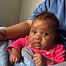 arm, baby, blanket, blue_blanket, child, clothing, curious, cute, expression, face, hand, human, indoor, infant, person, pink_clothing, portrait, sitting, skin, tattoo