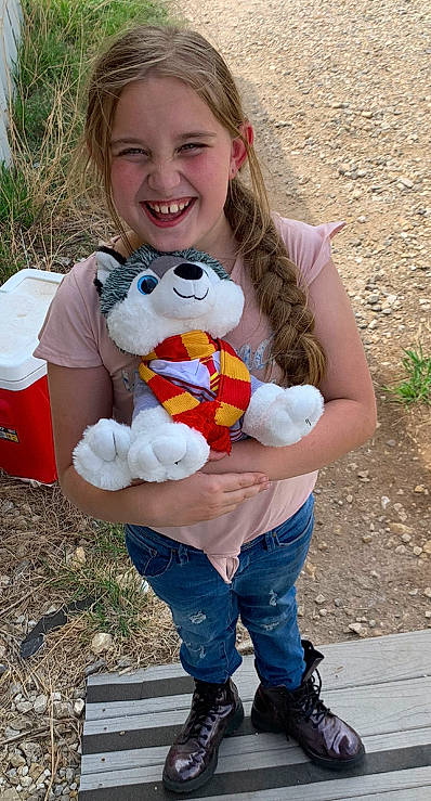 Haylee is registered to the contest to win money with this photo: blond, blue, child, costume, facial_expression, fun, glove, grass, hairstyle, happy, jeans, joy, leisure, people_in_nature, person, photograph, recreation, smile, stuffed_toy, teddy_bear