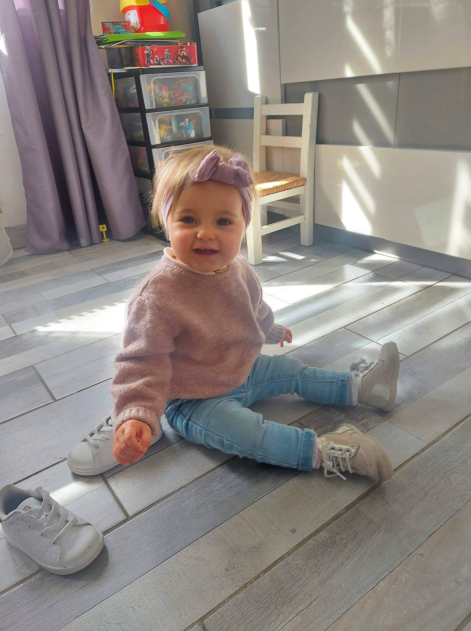 Iris a rejoint le concours — aidez-le/la à gagner de superbes lots ! baby_toddler_clothing, child, floor, flooring, foot, footwear, fun, hardwood, human_leg, joint, leg, person, shelf, shoe, sitting, sneakers, standing, toddler, varnish, wood