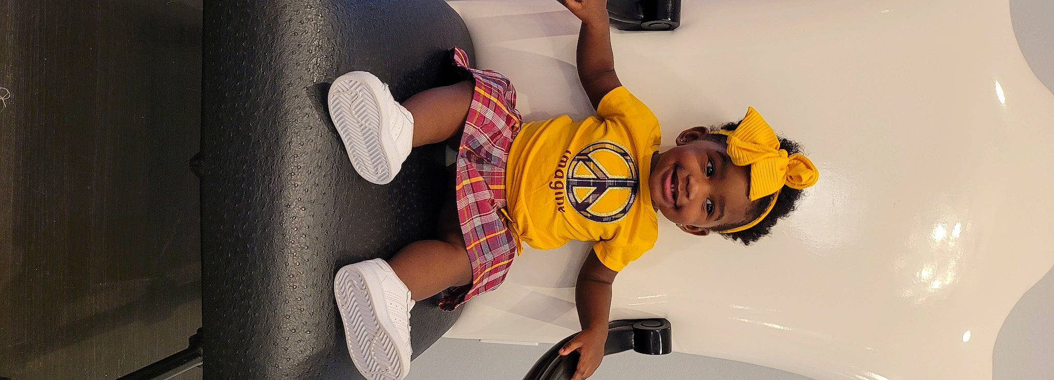 Mulan is registered to the contest to win money with this photo: automotive_design, chair, comfort, happy, headgear, headwear, human_leg, joy, knee, leg, leisure, mouth, person, personal_protective_equipment, shoe, shorts, smile, sneakers, sock, t_shirt