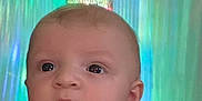 Archie is registered to the contest to win money with this photo: baby, child, face, eyes, hand, clothing, indoor, chandelier, light, colorful, reflection, curious, portrait, person, infant, cute, expression, skin, short_sleeves, holding