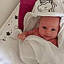 baby, bed, blanket, child, cute, face, happy, hood, indoors, infant, lying_down, newborn, portrait, skin, smile, soft, star_pattern, towel, unicorn, wrapped