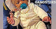 Tylan is registered to the contest to win money with this photo: baby, infant, stroller, pacifier, clothing, hoodie, gold_chain, indoor, floor, wooden_floor, cute, child, sitting, blue_stroller, footwear, expression, young_child, portrait, text_overlay, casual