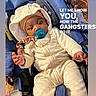 baby, infant, stroller, pacifier, clothing, hoodie, gold_chain, indoor, floor, wooden_floor, cute, child, sitting, blue_stroller, footwear, expression, young_child, portrait, text_overlay, casual