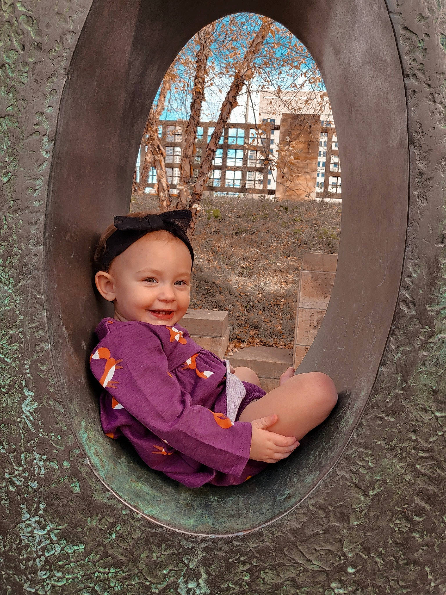 Augustina is registered to the contest to win money with this photo: automotive_tire, automotive_wheel_system, brick, chin, circle, door, flash_photography, fun, hair, hairstyle, happy, human_body, joy, leaf, person, plant, tints_and_shades, toddler, tree, wall