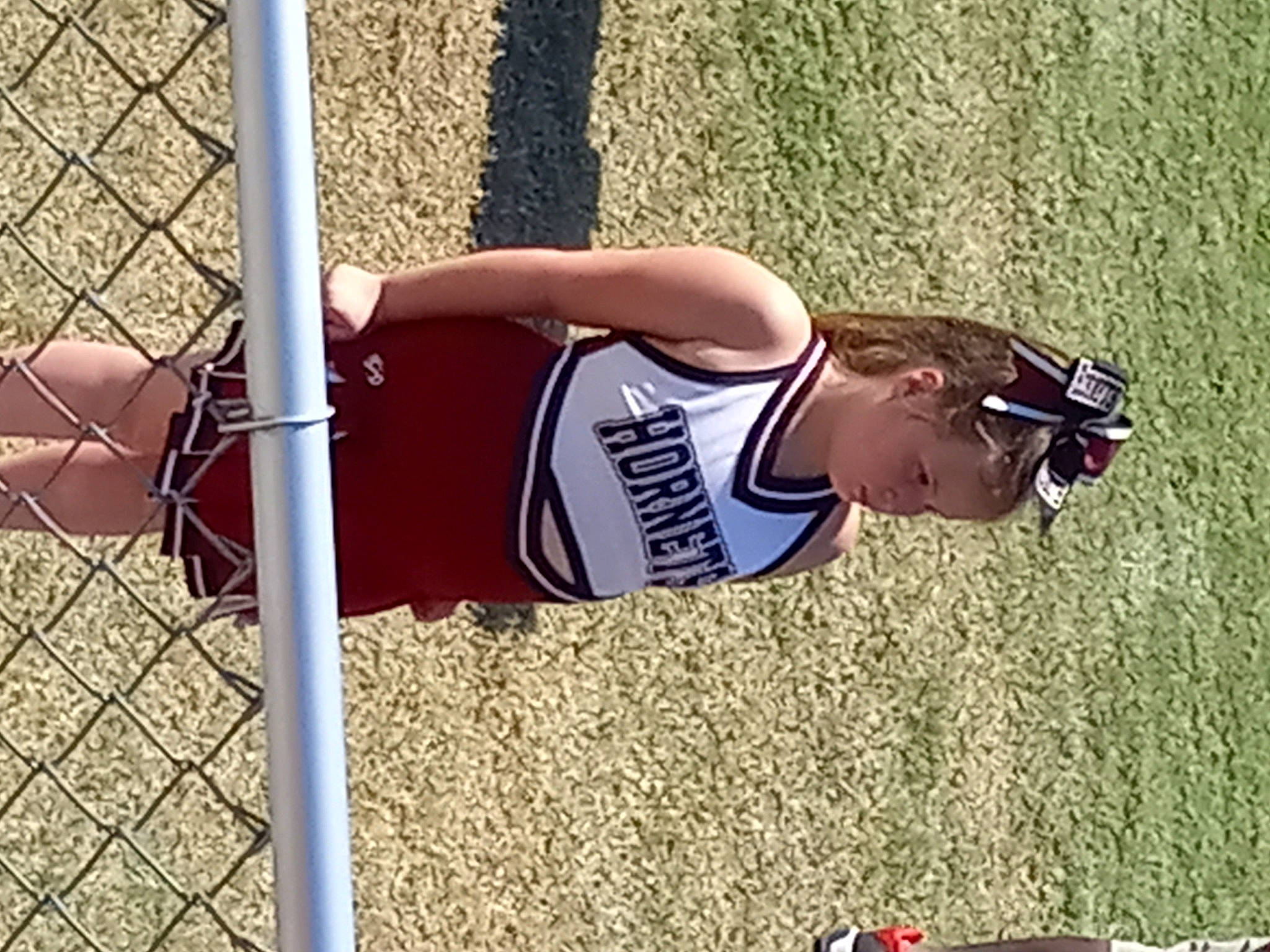 Elizabeth is registered to the contest to win money with this photo: ball_game, competition_event, elbow, fence, grass, human_leg, jersey, knee, person, player, shorts, sleeveless_shirt, sports, sports_gear, sports_uniform, sportswear, team_sport, thigh, tournament, waist