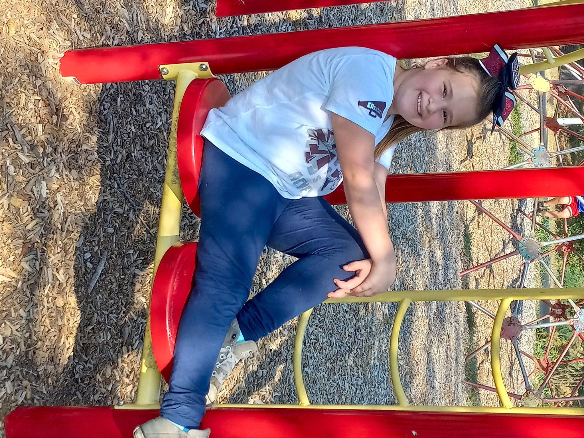 Elizabeth is registered to the contest to win money with this photo: balance, carmine, child, electric_blue, entertainment, fictional_character, fun, human_leg, joy, knee, leisure, outdoor_play_equipment, person, play, recreation, red, shorts, smile, sportswear, t_shirt