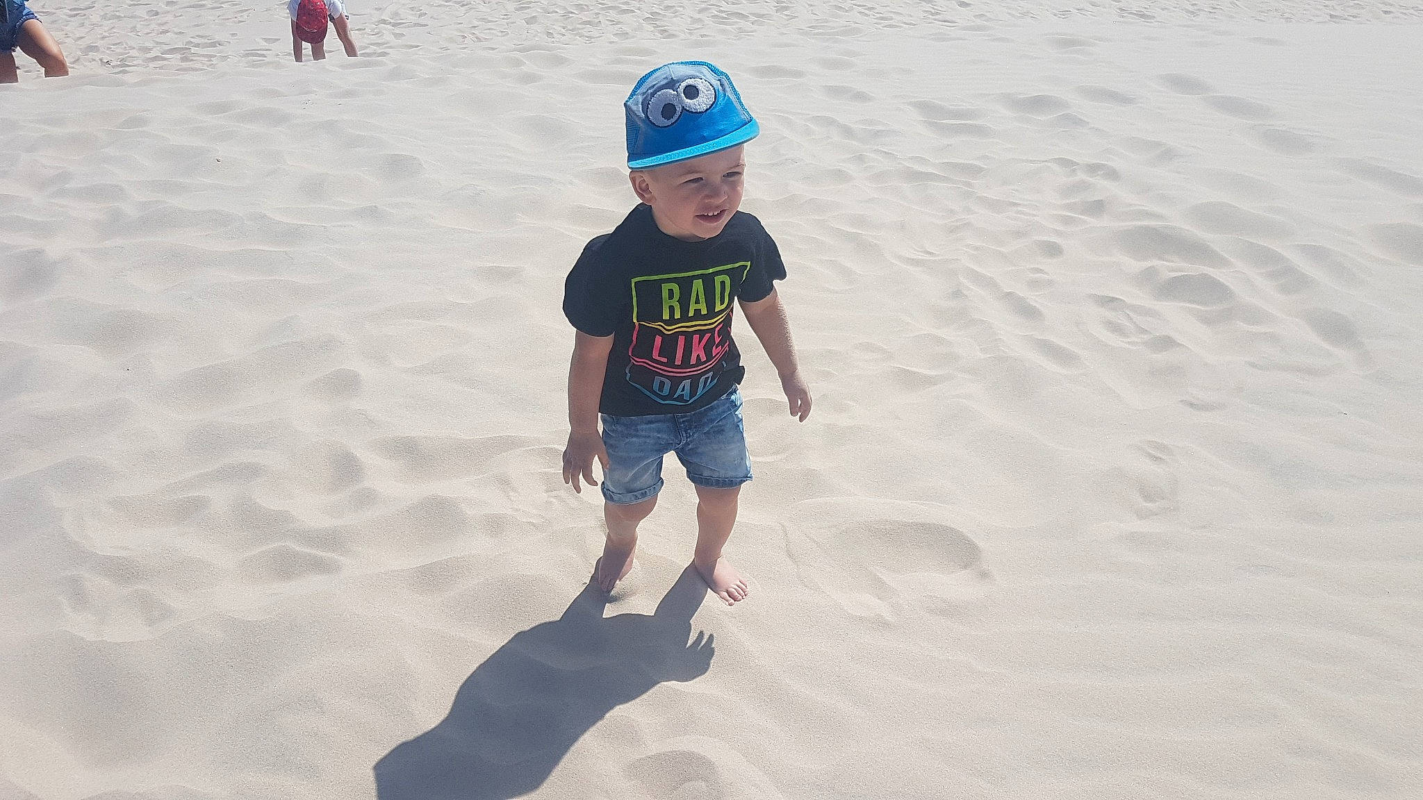 Maximilian is registered to the contest to win money with this photo: barefoot, beach, cap, child, fun, headgear, holiday, ocean, person, play, recreation, sand, sea, smile, summer, sun_hat, toddler, tourism, vacation, water