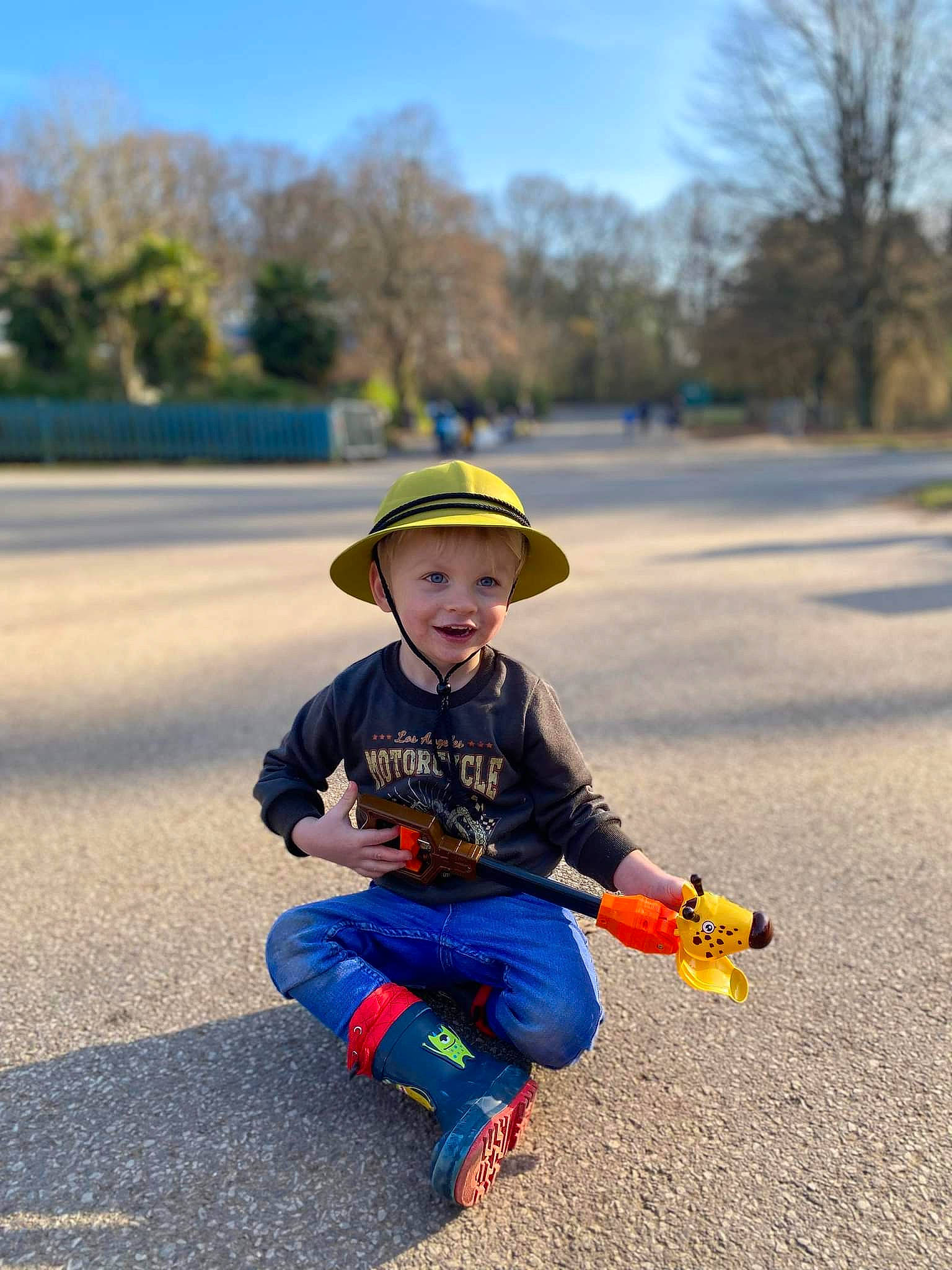 Theo-george is registered to the contest to win money with this photo: asphalt, cap, child, city, electric_blue, fun, grass, hat, headgear, headwear, joy, landscape, leisure, person, plant, recreation, road, sitting, sky, standing
