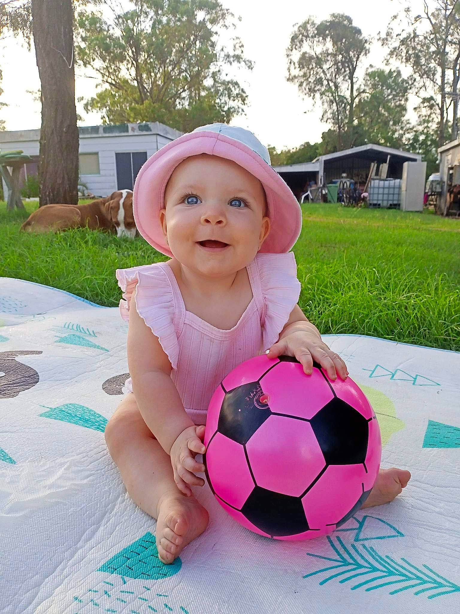 Charlie joined the competition — help win amazing prizes! baby_toddler_clothing, ball, ball_game, football, fun, grass, happy, hat, headwear, joy, leisure, person, pink, plant, recreation, smile, soccer, soccer_ball, sports_equipment, sun_hat