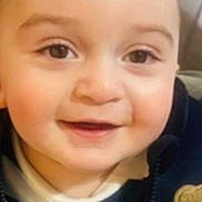 Adam is registered to the contest to win money with this photo: baby, cheeks, child, close_up, clothing, cute, expression, eyes, face, happy, head, indoors, infant, jacket, person, portrait, smiling, striped_shirt, teddy_bear_patch, young