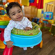 Velouria joined the competition — help win amazing prizes! baby, child, walker, smiling, curly_hair, indoor, playroom, toys, colorful, happy, person, infant, clothing, floor, furniture, seat, cute, young, portrait, hand
