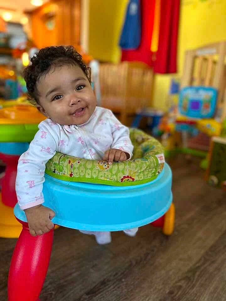 Velouria joined the competition — help win amazing prizes! baby, child, walker, smiling, curly_hair, indoor, playroom, toys, colorful, happy, person, infant, clothing, floor, furniture, seat, cute, young, portrait, hand
