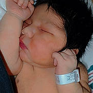 Kai is registered to the contest to win money with this photo: newborn, baby, sleeping, infant, wristband, hospital, blanket, pink, soft, peaceful, face, closed_eyes, skin, hair, arm, hand, portrait, resting, indoors, person