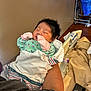 Kai joined the competition — help win amazing prizes! newborn, baby, infant, swaddled, mittens, green_outfit, sleeping, hospital_bed, adult_arm, blanket, water_bottle, phone, indoor, person, resting, close_up, human, soft_lighting, peaceful, tender_moment