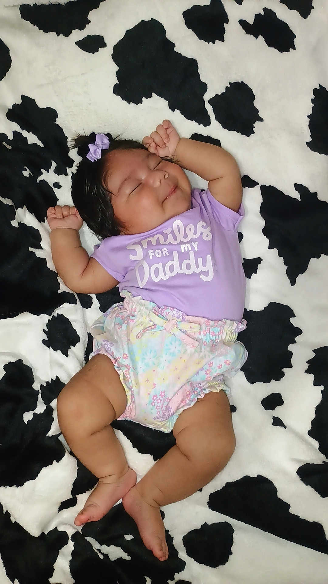 Kai joined the competition — help win amazing prizes! baby, sleeping, infant, purple_shirt, bow, blanket, cow_print, clothing, cute, peaceful, child, legs, arms, smile, relaxed, indoors, person, soft_texture, pattern, toddler