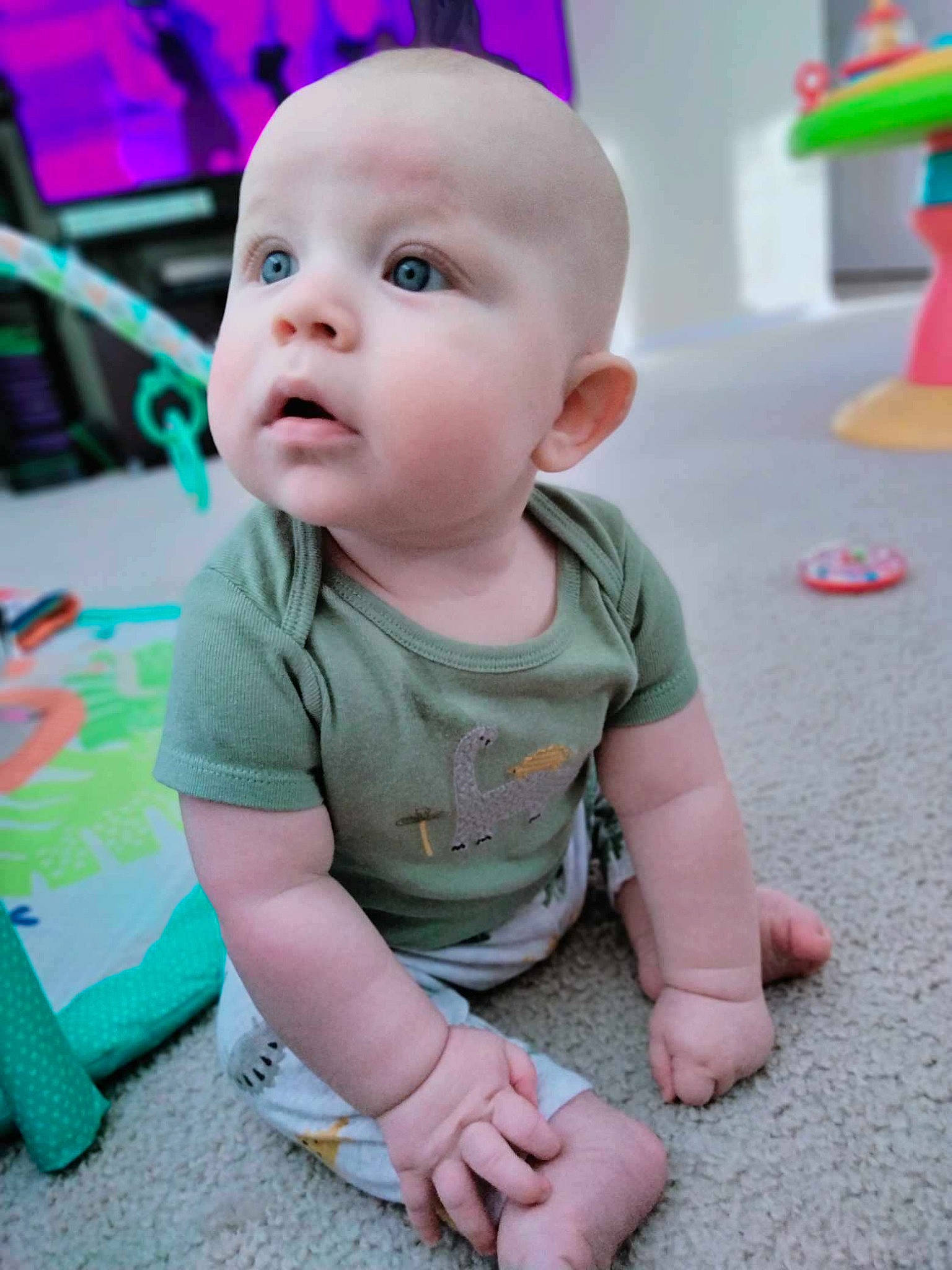 Tito is registered to the contest to win money with this photo: baby, baby_toddler_clothing, cheek, child, eye, finger, floor, flooring, fun, happy, human_body, iris, pattern, person, pink, sitting, skin, sleeve, standing, toddler