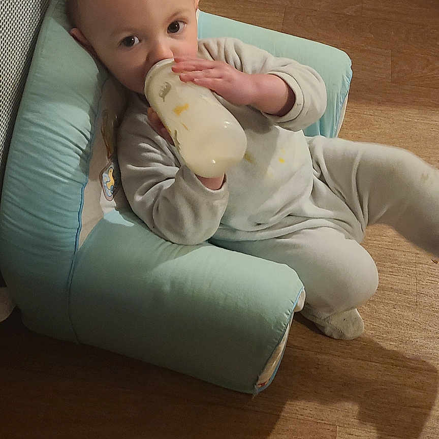 Maël a rejoint le concours — aidez-le/la à gagner de superbes lots ! architecture, baby, beverage, bodypart, chair, couch, cushion, face, finger, furniture, hand, hardwood, head, homedecor, milk, person, photography, portrait, sitting, wood